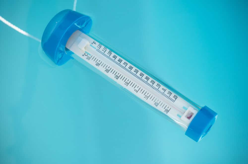 closeup of swimming pool thermometer floating on the water